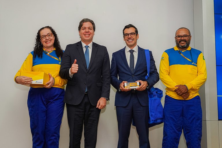 foto dos carteiros Cláudia e Luiz, acompanhados do ministro das comunicações e do presidente dos Correios